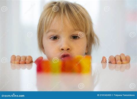 Cute Toddler Blond Boy, Looking at Colorful Gummy Bears on the Table ...