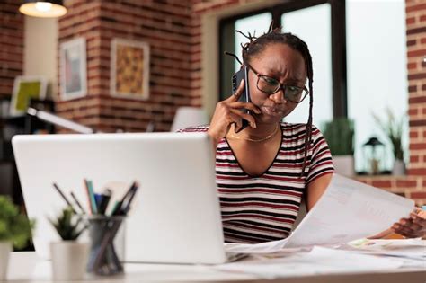 Serious freelancer answering mobile phone call, discussing report ...