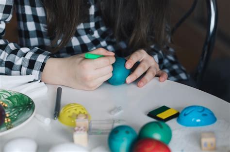 Midsection of girl drawing on easter egg | Premium Photo