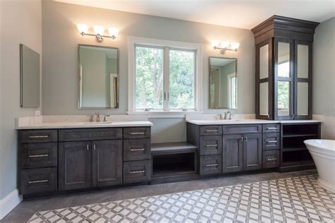 Master bathroom separate wood vanities with storage window seat between ...
