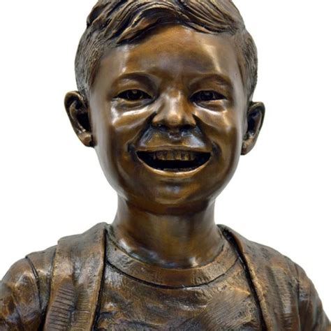 Colored outdoor statue of a child pressing their forehead on the hand of a seated elder