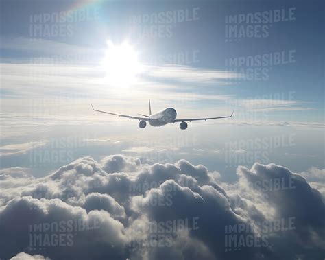 Plane in the sky travelling above the clouds - Impossible Images ...