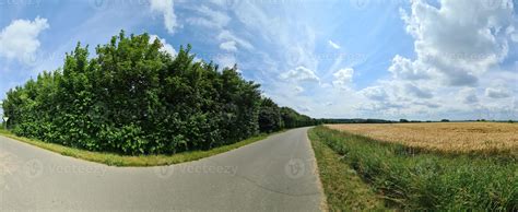 Beautiful high resolution panorama of a northern european country road with fields and green ...