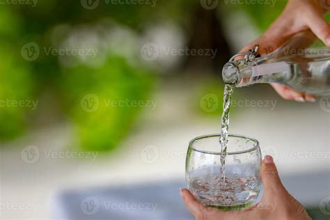 Pour water from a bottle into a glass. Pour a glass of water. An image ...