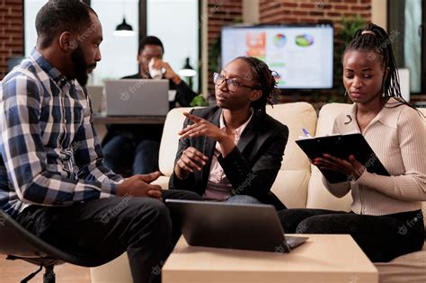 Office workers analyzing data on papers and laptop to plan online ...