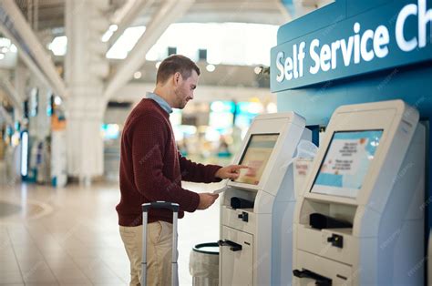 Man airport and self service kiosk for check in ticket registration or ...