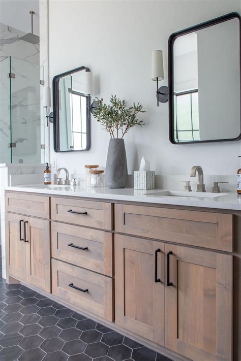 Wood vanities and a black hexagonal tile floor set this bathroom apart ...