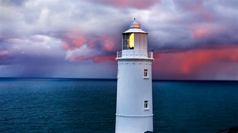 Trevose Head lighthouse under cloudy sky at sunrise, Cornwall, England ...