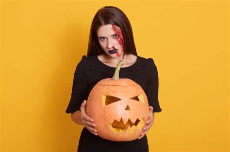 Plan intérieur d'une femme brune dans le maquillage d'Halloween tenant ...