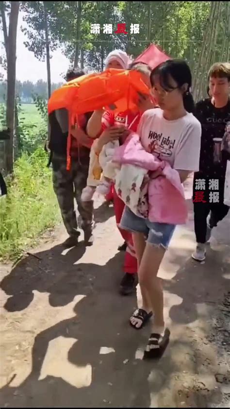 7月24日，河南新乡。救援人员转移出生未满10天的婴儿，小心翼翼用救生衣为其遮阳_凤凰网视频_凤凰网