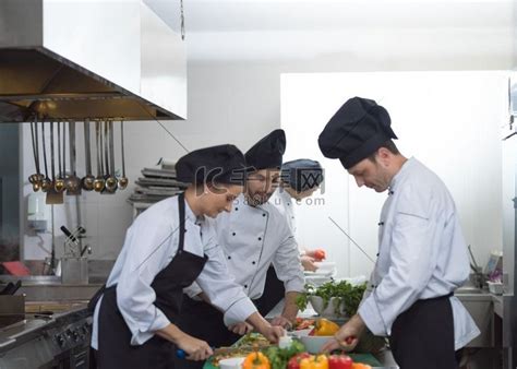专业团队的厨师和厨师在繁忙的酒店或餐厅厨房准备饭菜。合照人物特写高清摄影大图-千库网