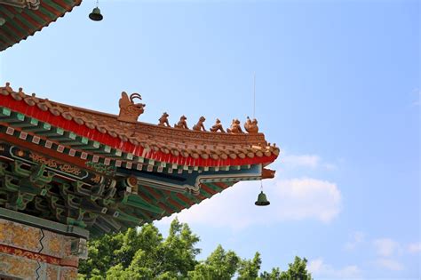 Photo of an elaborate Chinese temple with hedges in front.