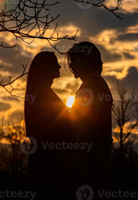 Silhouette of romantic couple in love, man and women in sunset sky ...