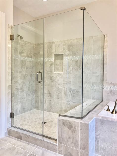 Clear frameless shower with notched inline panel and return panel on ...
