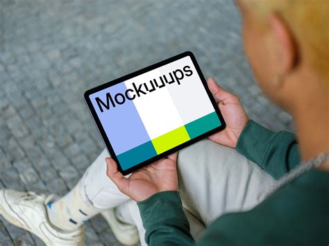 Young man holding iPad mockup - Mockuuups Studio