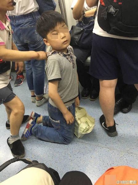 北京地铁一男孩被人拖住后背 跪地乞讨_天下新闻_海峡网