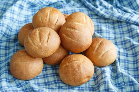 A few small round buns lie on the blue checkered fabric | Premium Photo