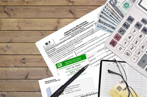IRS form W-7 Application for IRS individual taxpayer identification number lies on flat lay ...