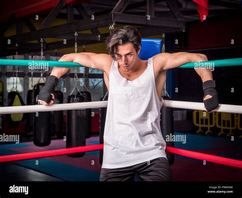 Determined muscular boxer hanging on ropes Stock Photo - Alamy