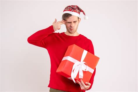 Front view young man with santa hat putting finger gun to his temple ...