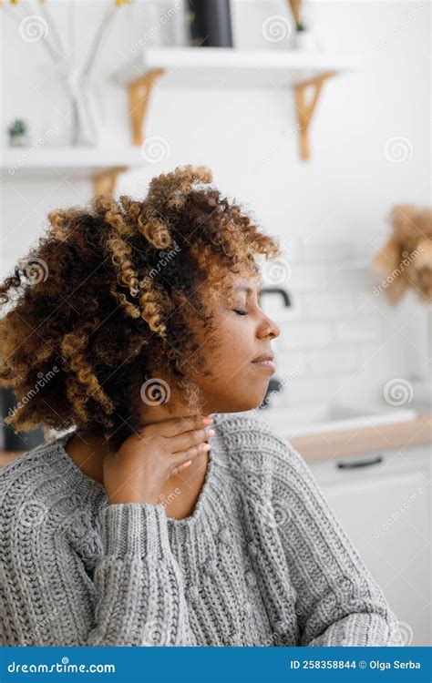 African American Woman with a Cold and Sore Throat Drinks Vitamins and ...