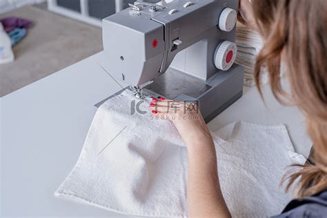 女人在家里的缝纫机上缝衣服高清摄影大图-千库网
