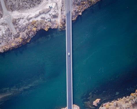 Download wallpaper 1280x1024 bridge, car, aerial view, river, coast ...