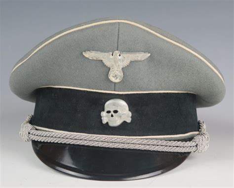 A WW2 German Waffen-SS officer's peaked cap with metal National emblem ...