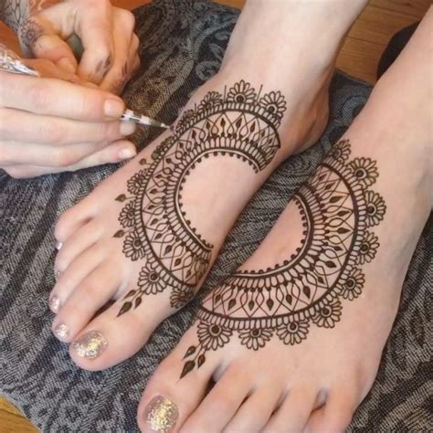 two feet with henna tattoos on them