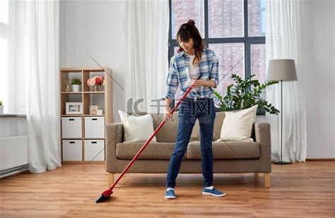 清洁家务和家政概念-快乐的亚洲女人用扫帚扫地，在家跳舞。室内一角服装高清摄影大图-千库网