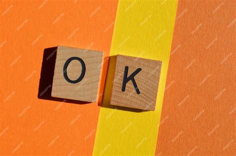 Premium Photo | Ok abbreviation for okay wooden alphabet letters isolated on orange and yellow