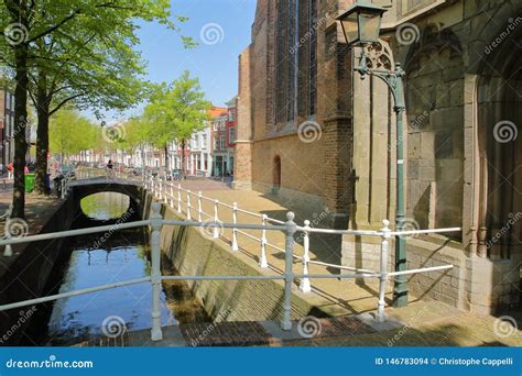 The Oude Delft Canal With The External Facade Of Oude Kerk On The Right ...