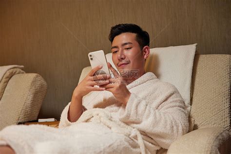 青年男性躺沙发上玩手机高清图片下载-正版图片502355911-摄图网