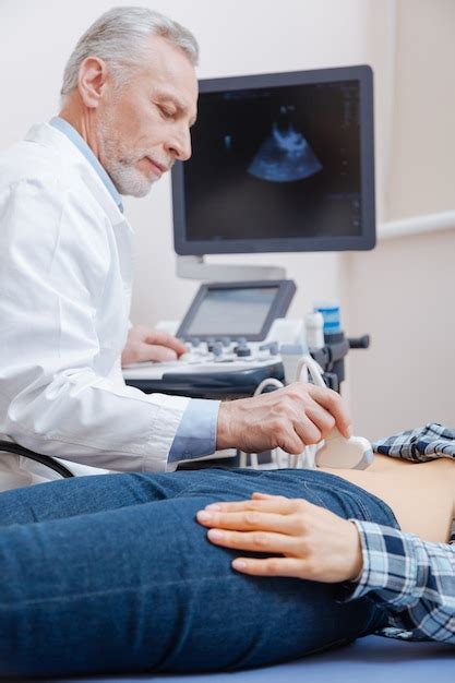 Charming peaceful skilled doctor enjoying working hours in the hospital ...