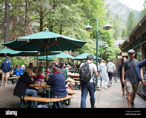 Tourists dine at outdoor tables near the Village Grill restaurant in ...