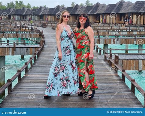 Mother And Daughter In Matching Tropical Dresses Standing Together On ...