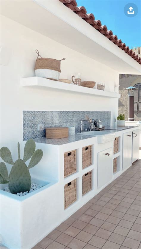 an outdoor kitchen with white cabinets and tile flooring on the outside ...