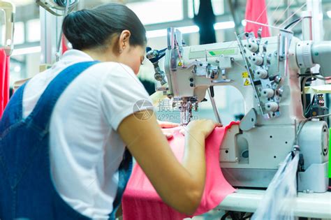 纺织厂的妇女缝纫车间工人在缝纫机上工作图片-包图网企业站