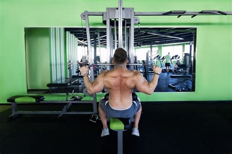 Muscular man working out in gym doing exercises at triceps strong male ...