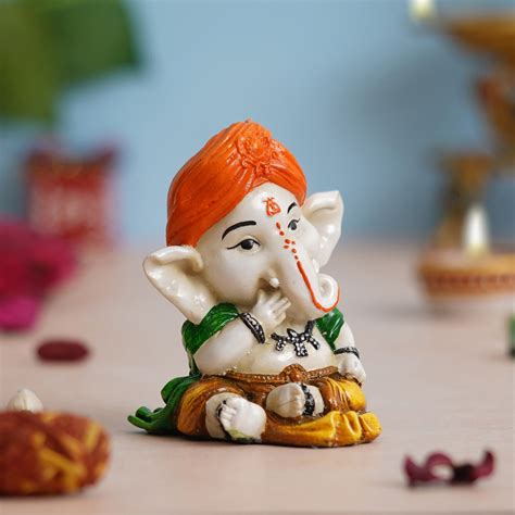 eCraftIndia Orange Polyresin Handcrafted Eating Lord Ganesha Idol whil