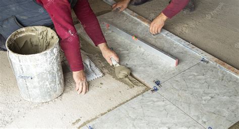Premium Photo | Worker using spatula and putting glue on floor