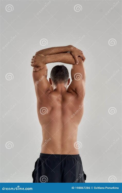 Rear View of Muscular Man with Naked Torso Raising His Arms Above Head ...