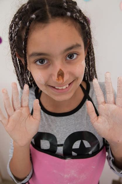 Close-up portrait of smiling girl with chocolate cream on nose ...