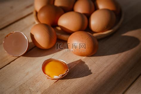 鸡蛋放在木托盘上，鸡蛋破了。高清摄影大图-千库网