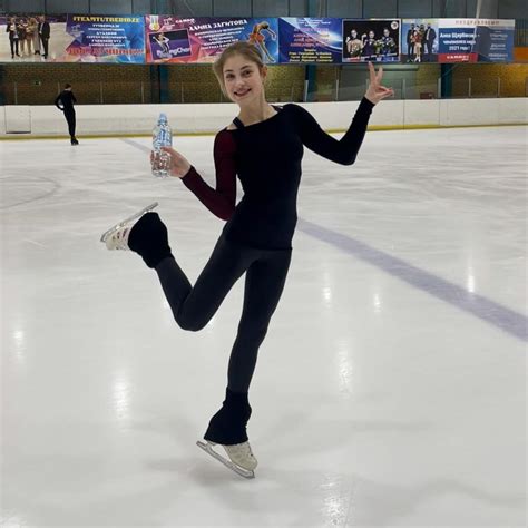 a woman is skating on an ice rink and posing for the camera with her ...