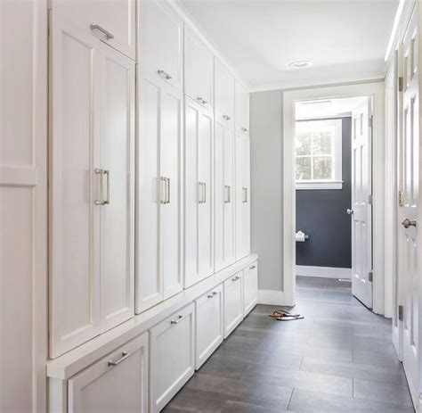 Galley style mudroom featuring floor to ceiling built-in cabinets with ...