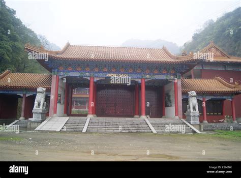 Photo of an elaborate Chinese temple with hedges in front.