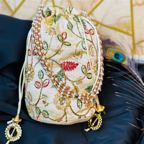 Ivory Zari Embroidered Potli with Multicolor Floral Work & Pearl Handl ...