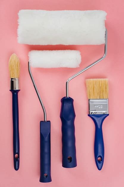 Paint rollers and brushes on a pink background. tools for painting and ...