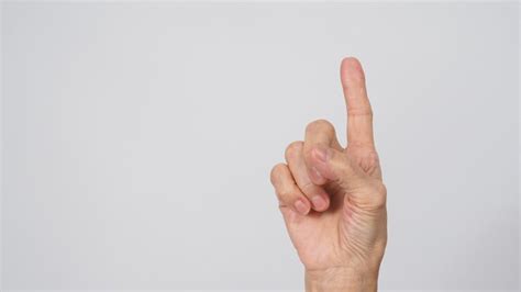 Senior or older woman is doing one finger or point up hand sign on ...